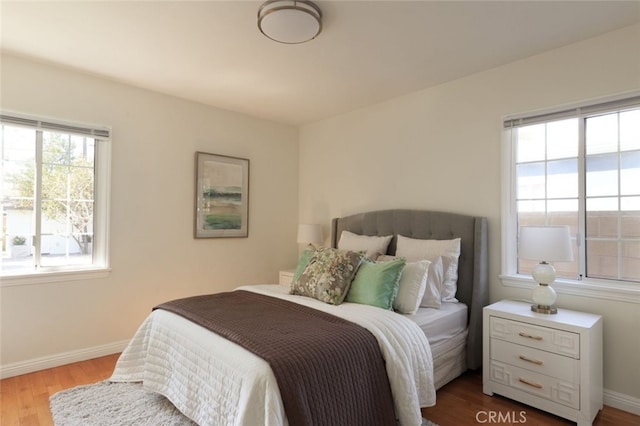 bedroom featuring baseboards and wood finished floors