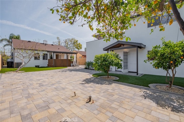 back of house featuring a lawn and stucco siding