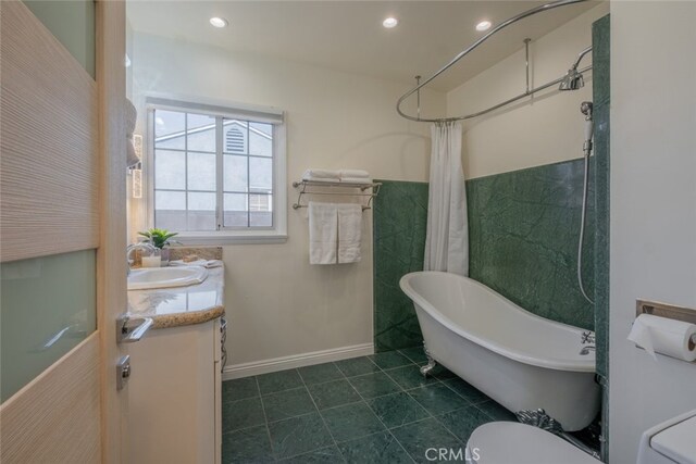 bathroom with tile patterned floors, recessed lighting, vanity, and a freestanding tub