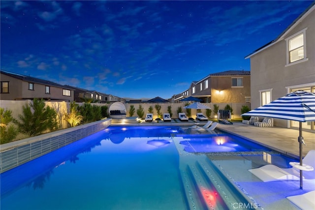 view of pool featuring a patio, a fenced backyard, and a pool with connected hot tub