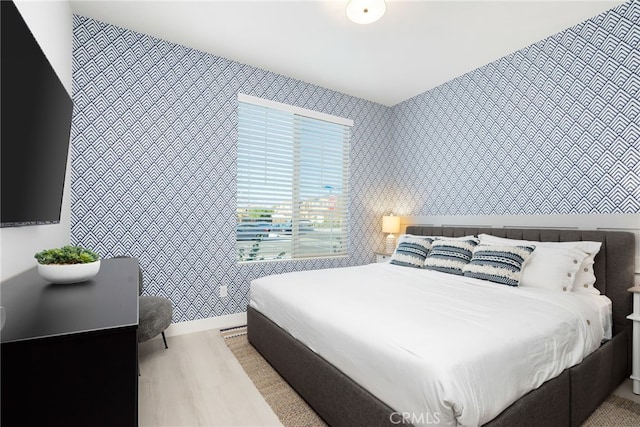 bedroom featuring light wood-type flooring and wallpapered walls