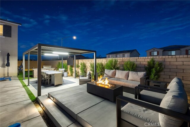 patio at twilight featuring a fenced backyard, outdoor dining area, and an outdoor living space with a fire pit