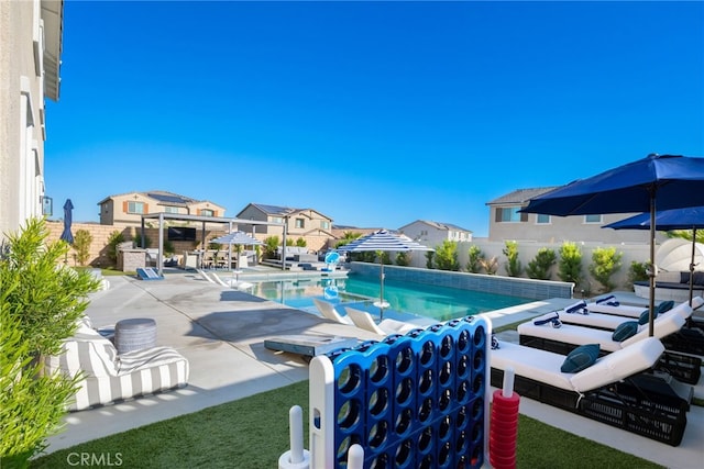 view of swimming pool featuring a patio, a residential view, a fenced backyard, and a fenced in pool