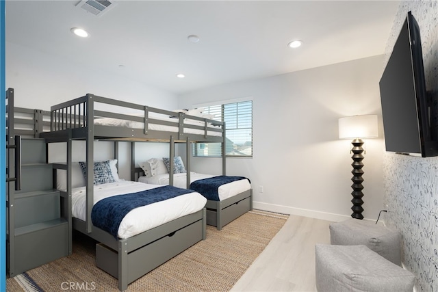 bedroom with baseboards, wood finished floors, visible vents, and recessed lighting