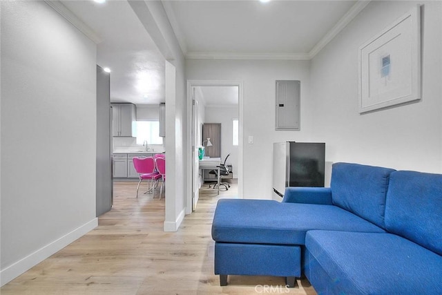 living room with electric panel, crown molding, light wood-style flooring, and baseboards