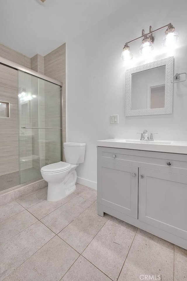 full bathroom with toilet, a shower stall, vanity, tile patterned flooring, and baseboards