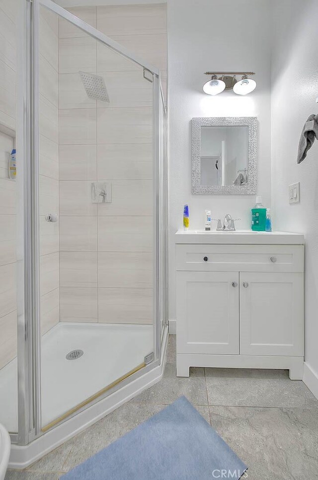 bathroom with a shower stall and vanity