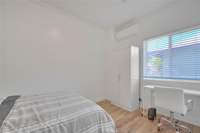 bedroom featuring an AC wall unit and light wood-style floors