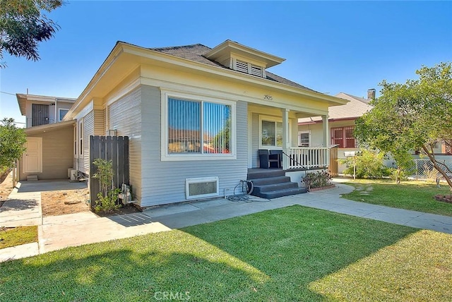 view of front of property with fence, a front lawn, and a porch