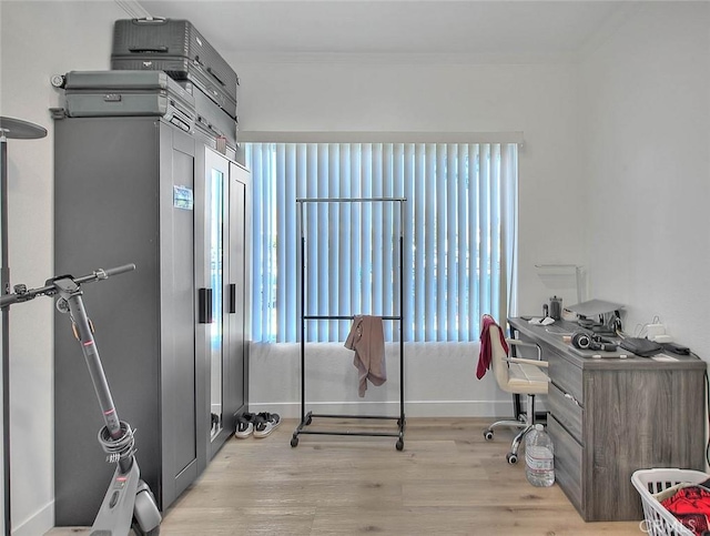 office space featuring light wood-style flooring, baseboards, and ornamental molding