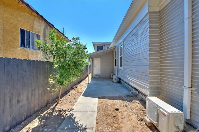 view of side of property featuring ac unit, a patio area, and fence