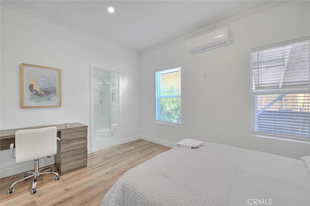 bedroom featuring baseboards, ensuite bathroom, a wall mounted air conditioner, light wood-type flooring, and recessed lighting