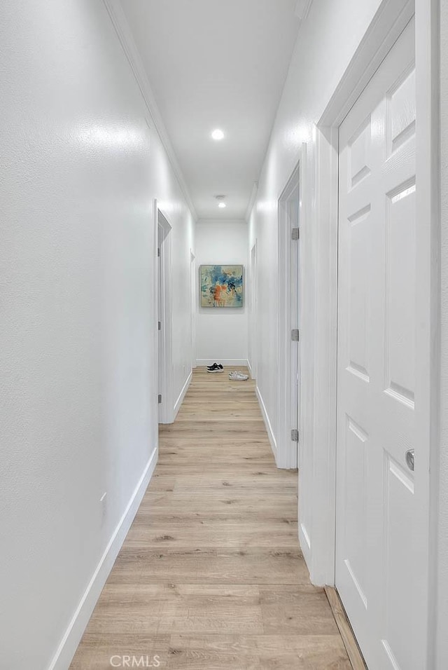 hall with light wood finished floors, recessed lighting, baseboards, and ornamental molding