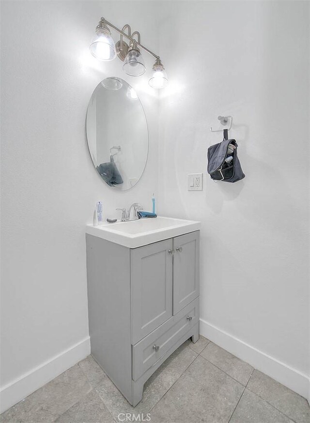 bathroom featuring tile patterned floors, baseboards, and vanity