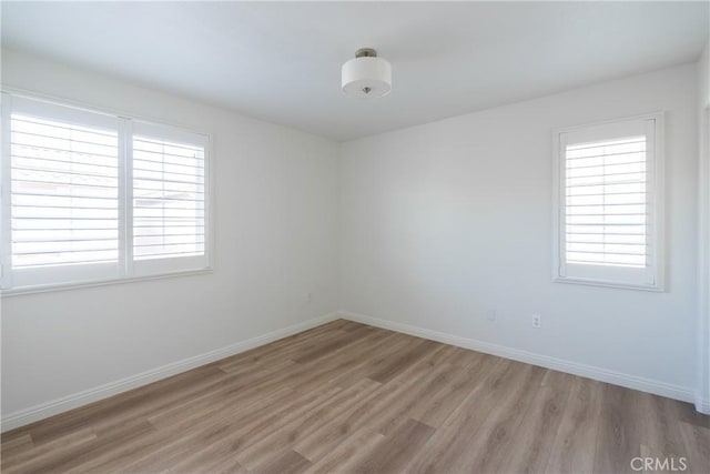 empty room with light wood finished floors and baseboards