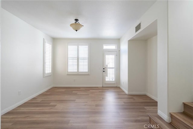 entryway featuring light wood finished floors, baseboards, and visible vents