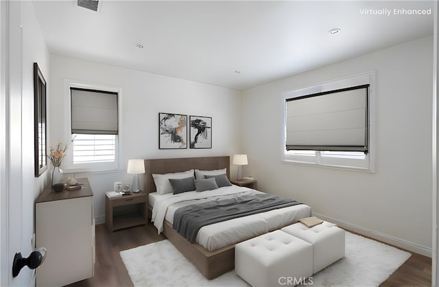 bedroom featuring visible vents, baseboards, and wood finished floors