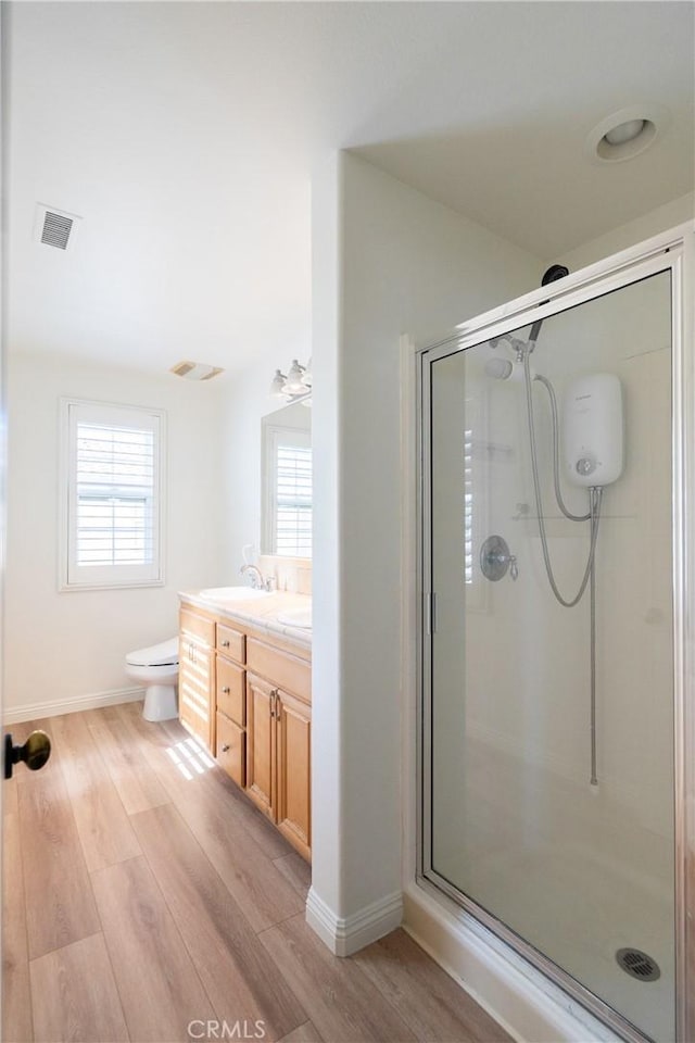 full bath with a stall shower, wood finished floors, and visible vents