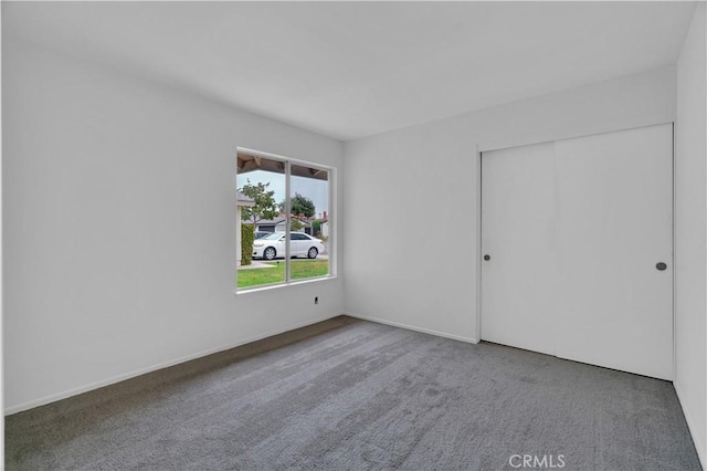 unfurnished bedroom featuring a closet, carpet, and baseboards