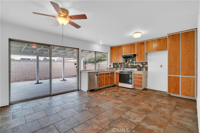 kitchen with white gas stove, light countertops, stainless steel dishwasher, decorative backsplash, and brown cabinetry