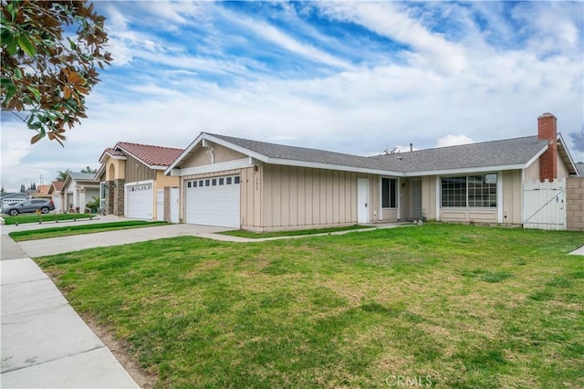 ranch-style home featuring driveway, an attached garage, a gate, fence, and a front yard