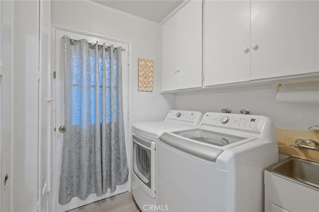 laundry room featuring cabinet space, separate washer and dryer, and a sink