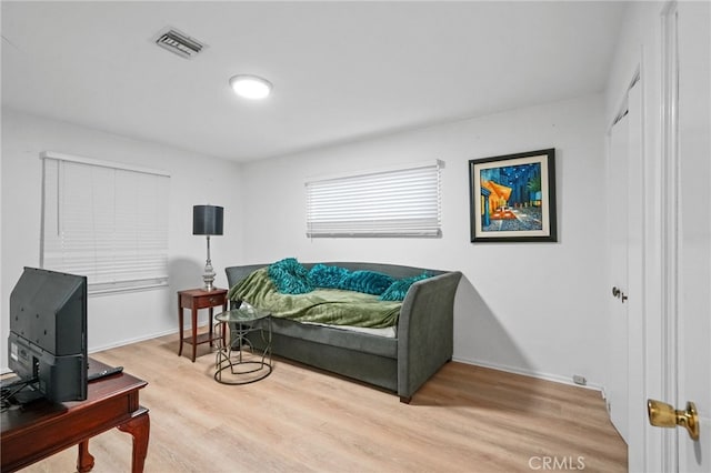 bedroom with visible vents, baseboards, and light wood finished floors