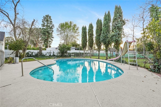 view of pool featuring a fenced in pool, a patio, a water slide, and fence