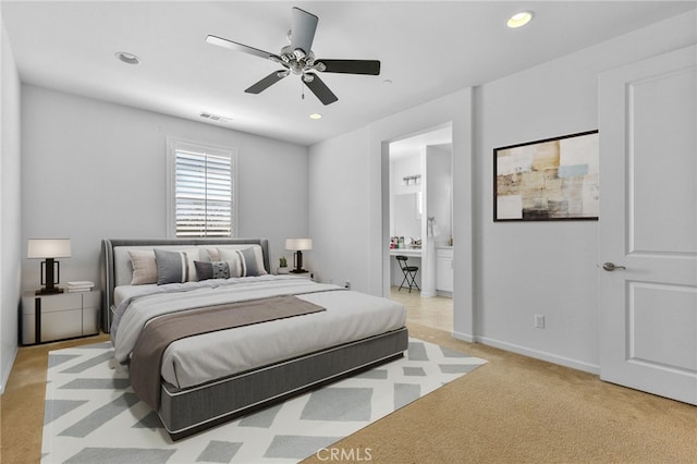 bedroom featuring light colored carpet, recessed lighting, visible vents, baseboards, and ensuite bath