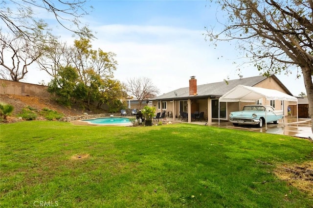 view of yard with a patio, fence, and an outdoor pool