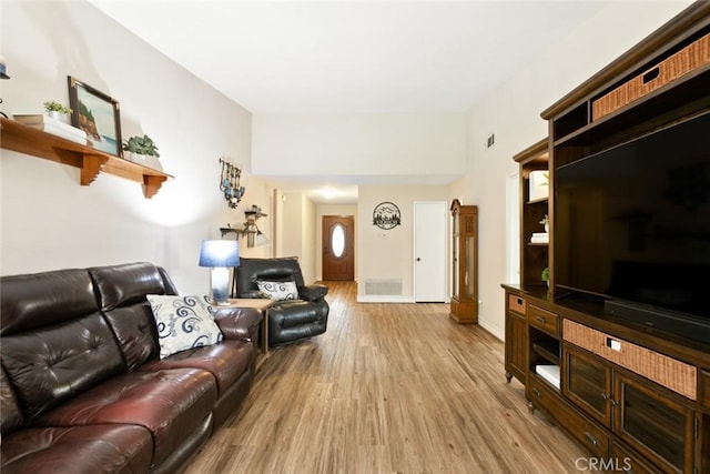 living area featuring light wood-style flooring, visible vents, and baseboards