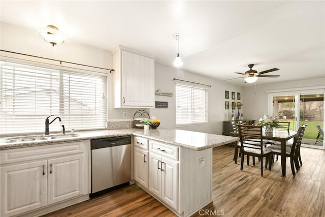 kitchen with a wealth of natural light, a sink, a peninsula, and stainless steel dishwasher