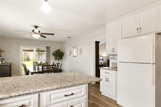 kitchen with ceiling fan, wood finished floors, freestanding refrigerator, and white cabinetry