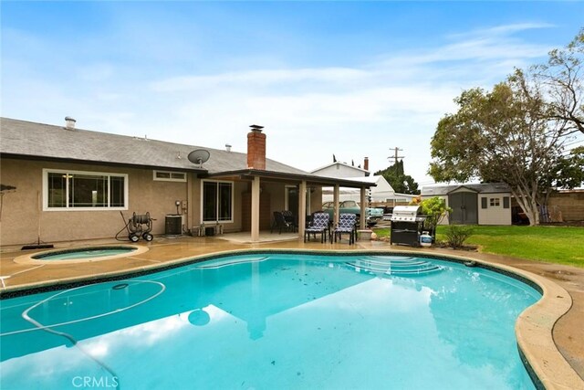 pool featuring an in ground hot tub, a storage unit, an outdoor structure, central air condition unit, and a patio area