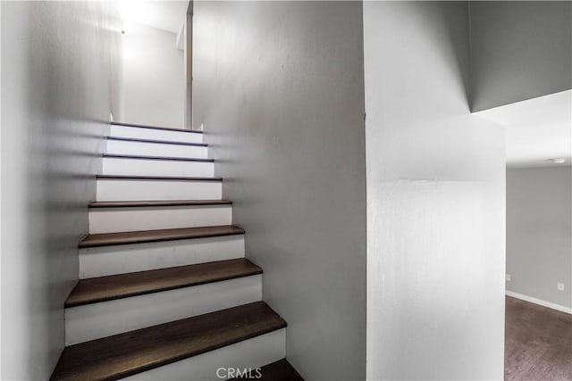 stairway featuring baseboards and wood finished floors