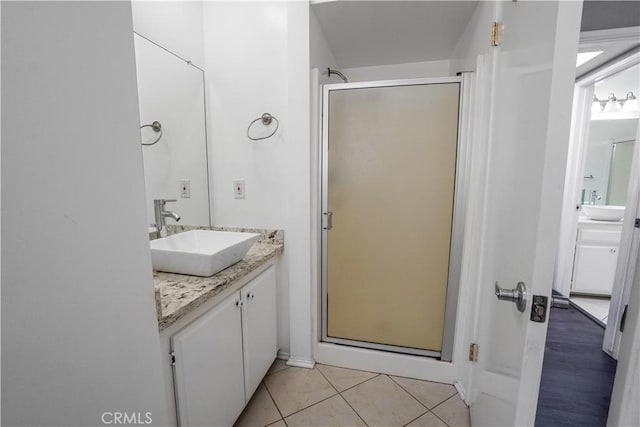 bathroom featuring tile patterned flooring, a stall shower, and vanity