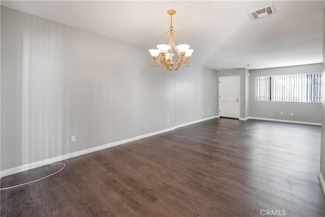 unfurnished room featuring dark wood-style floors, visible vents, a chandelier, and baseboards