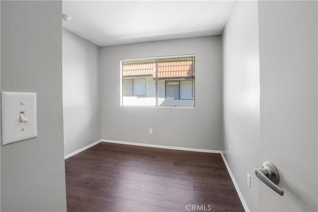 unfurnished room with wood finished floors and baseboards