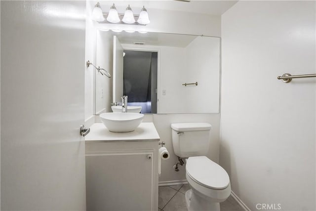 bathroom featuring tile patterned flooring, toilet, vanity, and baseboards