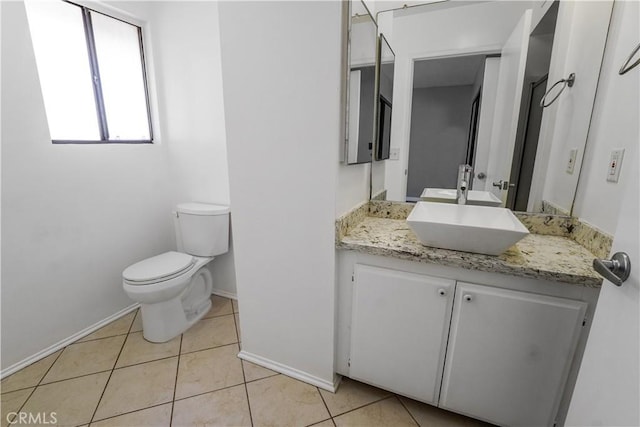 bathroom featuring tile patterned flooring, toilet, vanity, and baseboards