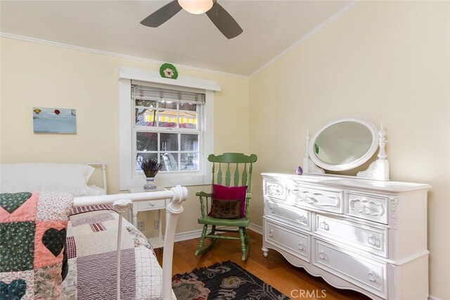 bedroom with baseboards, wood finished floors, a ceiling fan, and crown molding