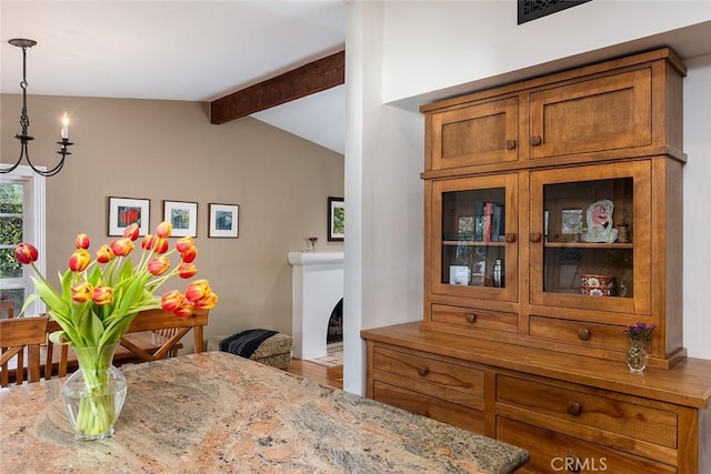 dining area featuring lofted ceiling with beams and visible vents