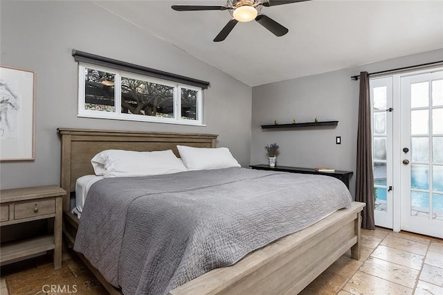 bedroom featuring lofted ceiling, a ceiling fan, and stone tile floors