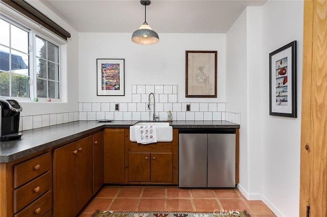 kitchen featuring dark countertops, light tile patterned flooring, a sink, dishwasher, and fridge