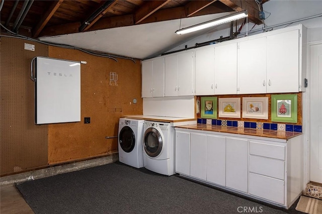 washroom featuring a garage, independent washer and dryer, and cabinet space