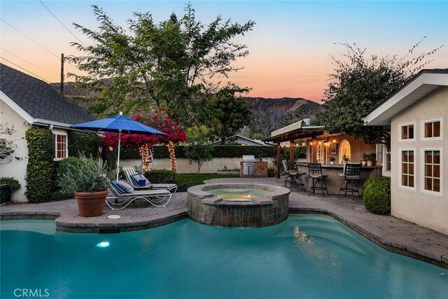 view of pool with outdoor dry bar, an in ground hot tub, a patio, and a fenced in pool