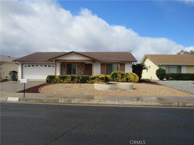 ranch-style house with driveway, a garage, and brick siding