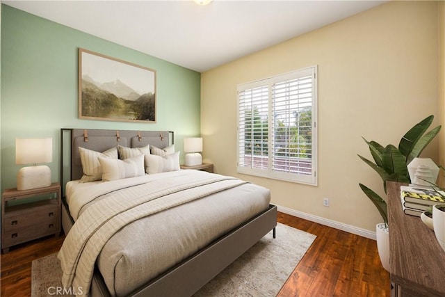 bedroom with dark wood finished floors and baseboards