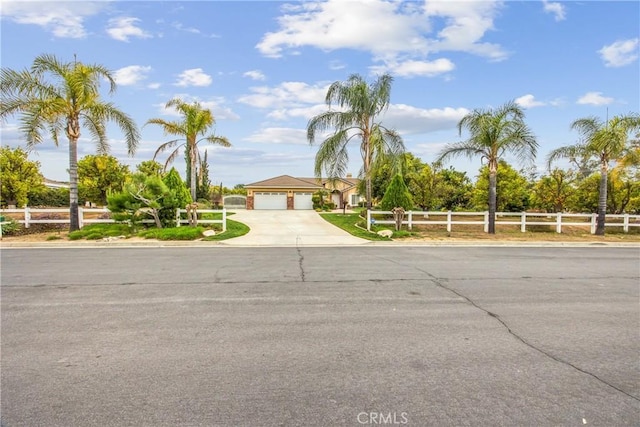 view of front of house with driveway, an attached garage, and fence