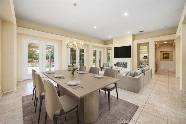 dining area featuring french doors, light tile patterned floors, recessed lighting, visible vents, and a glass covered fireplace